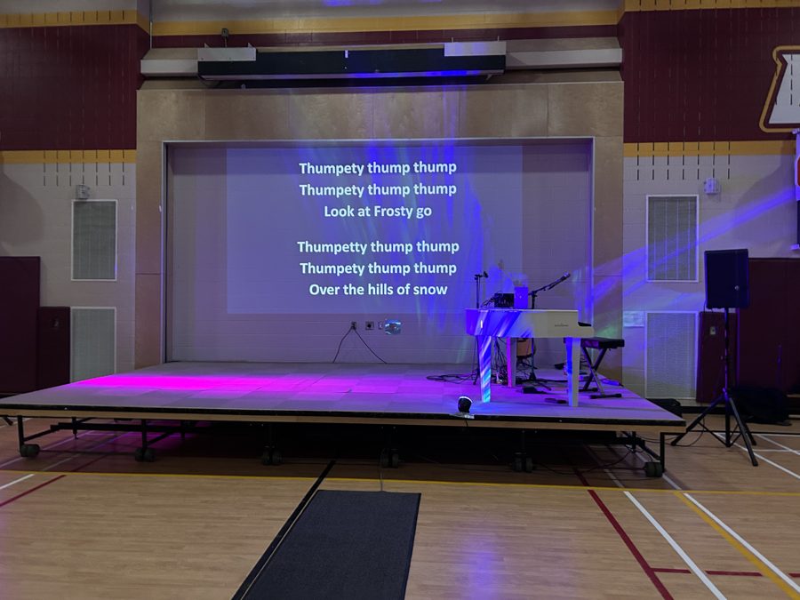 The gym stage during the Christmas Sing-Along with the lyrics to Frosty the Snowman on the big screen