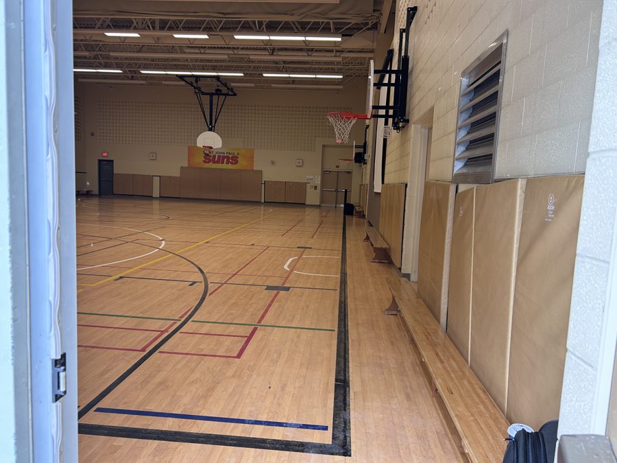 An empty elementary school gym before setup, with the stage end clear