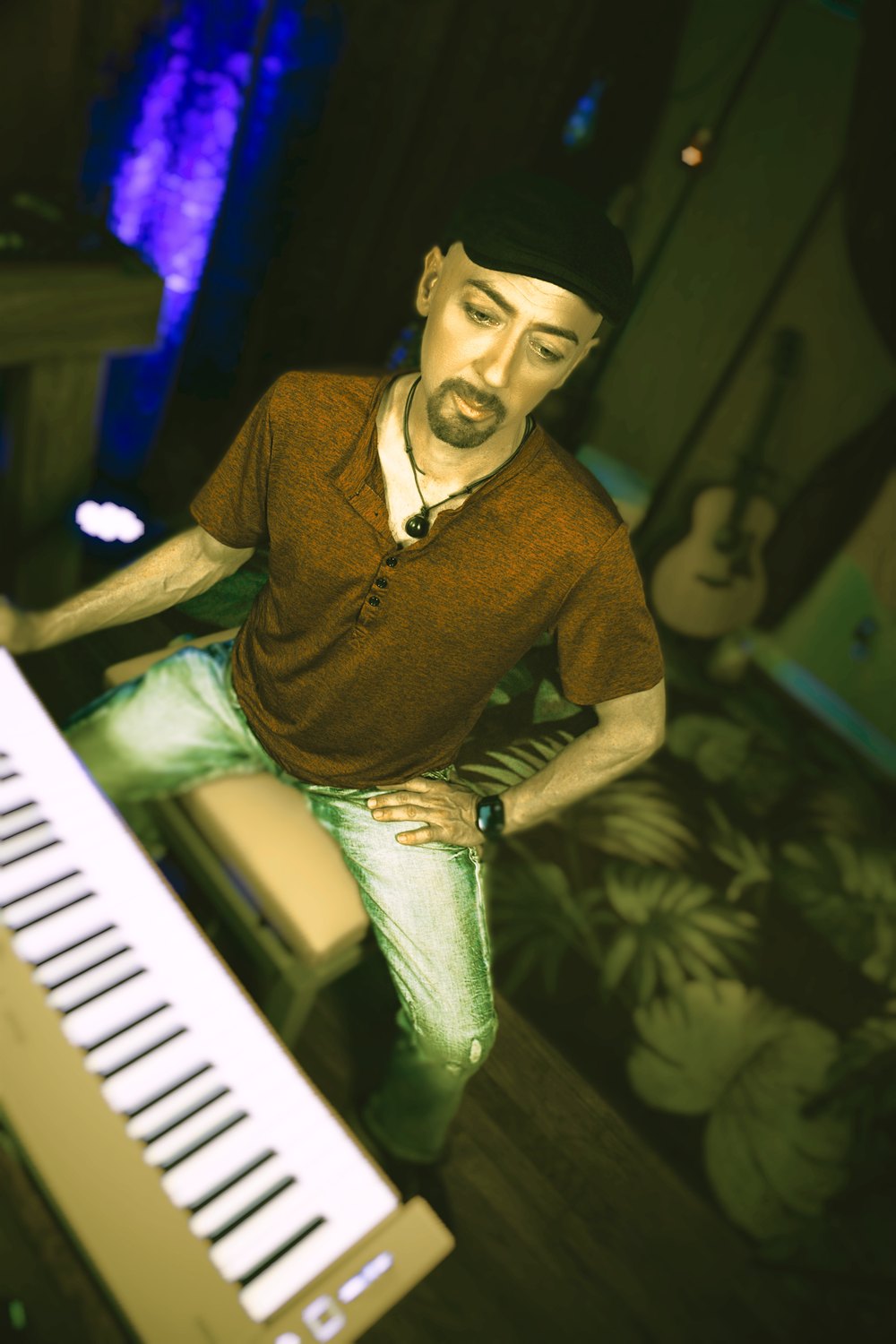 Jamie Mahn at the keys mid-set, lit in green and blue stage light.